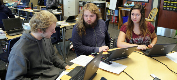 Ashley Bull (right) critiques a writing assignment with classmates.
