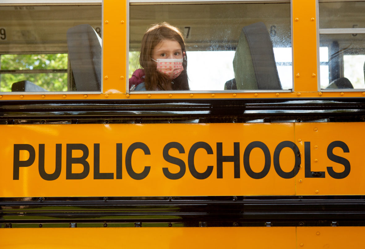 An elementary student waits for her bus to leave school after dismissal. <br><strong> Photo by Allison Shelley for American Education: Images of Teachers and Students in Action </strong>