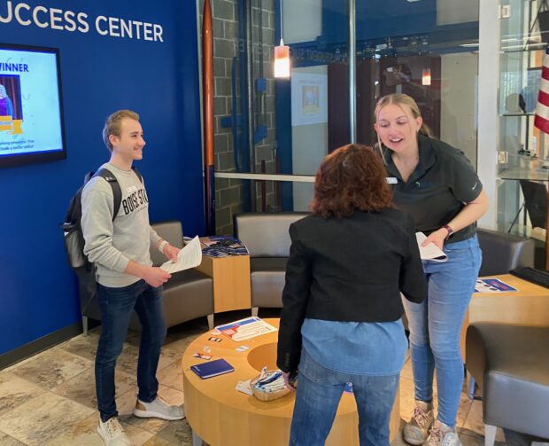 Student ambassadors Bowen Moser (left) and Lydia Rice (right) speak with Micron communications specialist Lynda Martin (center).