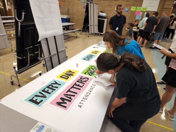 Students add their signature the 'Every Day Matters' banner at the beginning of the school year.