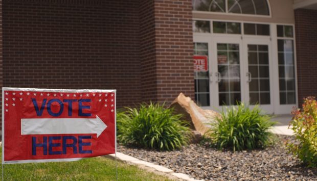 A sign directs voters to the entrance of a polling place in a Church of Jesus Christ of Latter-Day Saints church gymnasium.