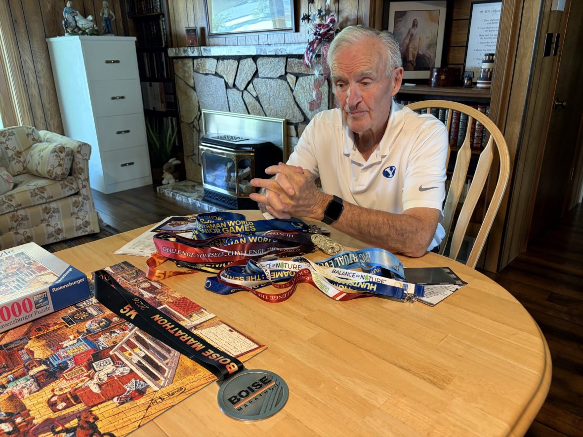 Coach overlooking his many 5K medals. (Devin Bodkin/EdNews)